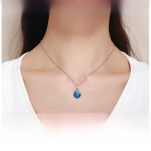 Detail of S925 silver dolphin pendant necklace with blue crystal on a model neck