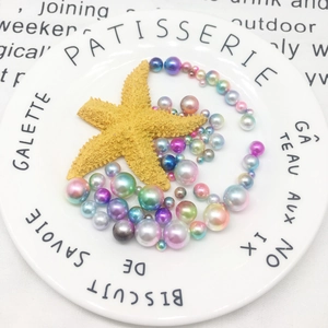 Close-up of assorted iridescent mermaid pearls and yellow starfish for DIY craft projects