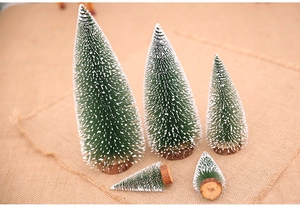 Detailed view of mini snow-flocked Christmas trees with wood bases on burlap background