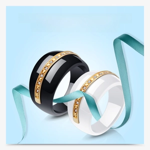 Close-up of black and white ceramic rings with gold inlay and pavé set diamonds