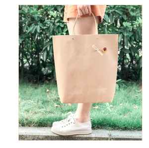 Close-up of a brown kraft paper gift bag with floral decor and a handheld strap
