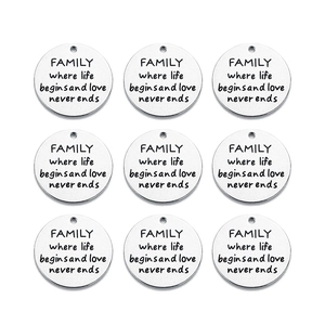 Flat lay of nine silver stainless steel discs engraved with family quote on white background