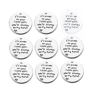 Macro view of five silver stainless steel round charms with sentimental hero engraving