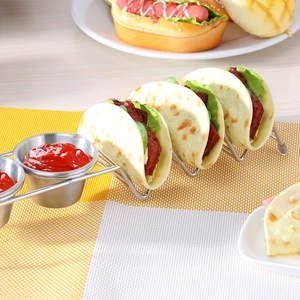 Stainless steel taco holder with four shells and two sauce cups on checkered mat