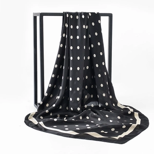Macro detail of elegant black polka dot satin silk scarf draped on a modern metal frame