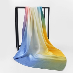 Detail of gradient rainbow silk scarf hanging on a rack showing soft texture and drape
