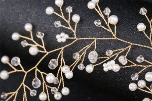 Détail d'une vigne de cheveux de mariée dorée avec perles blanches et cristaux clairs