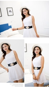 Detail of wide black elastic waist belt with gold embossed cat's eye stone buckle