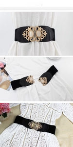 Detail view of women's elastic waist belt with cat eye stone and gold metal buckle