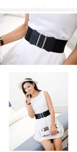 Detail of wide black elastic waist belt with silver interlocking buckles and faux leather trim