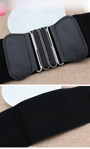 Detail of black wide elastic waist belt with faux leather buckle and metal hardware