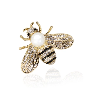Elegant gold bee brooch with white rhinestones and a central pearl on a white background