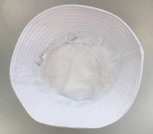 Detail of white cotton bucket hat interior showing stitching and 100% cotton care label