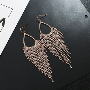Macro detail of rose gold waterdrop earrings with sparkling rhinestone fringe tassels