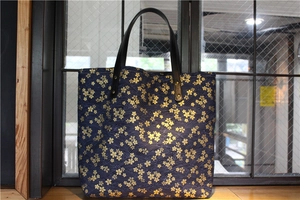Détail du sac cabas en toile marine avec motifs cerisiers et renfort de sangle en cuir