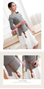 Detail of a slim brown woven tassel belt paired with a grey knit top and white chiffon skirt