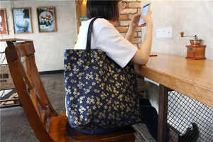 Sac cabas japonais en toile bleu marine avec motifs cerisiers dorés porté par un modèle