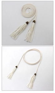 Close-up of white woven waist chain featuring elegant tassels and metal accents