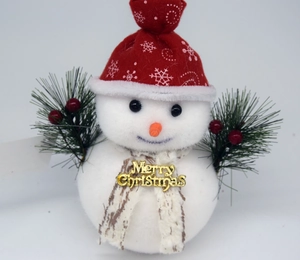 Détail d'un bonhomme de neige en peluche avec bonnet rouge et signe Merry Christmas doré