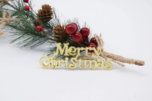 Détail de décoration de Noël avec inscription Merry Christmas dorée, pommes de pin et baies