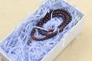 Detail of red garnet multi-layer bracelet with silver gourd charm in gift box