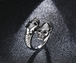 Macro detail of gothic double skull ring with vintage silver finish and scale texture