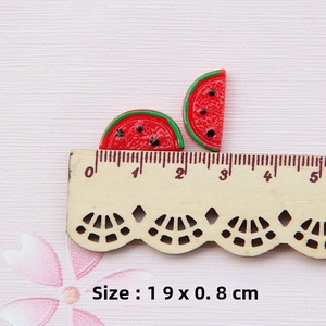 Detail view of 1.9x0.8cm resin watermelon slices for DIY jewelry on a wooden ruler