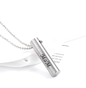 Macro shot of silver cylinder cremation pendant necklace featuring Mom engraving