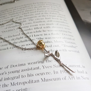 Golden rose pendant necklace in 925 sterling silver on vintage book background