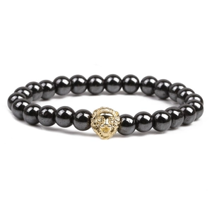 Bracelet fait main en hématite magnétique avec un charme de tête de lion doré sur fond blanc