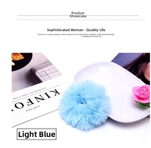Close-up of light blue plush scrunchie with soft faux fur texture on a white plate
