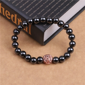 Détail du bracelet en hématite noire avec tête de lion or rose posé sur un livre ancien