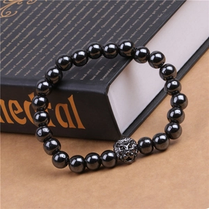 Vue détaillée du bracelet en perles d'hématite magnétique avec charm tête de lion en métal