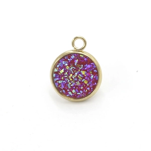 Detail showing a round gold resin pendant with purple and blue glitter texture