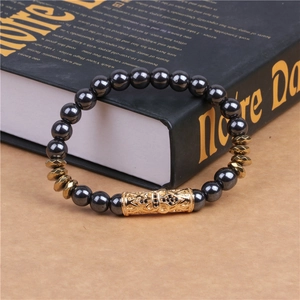 Bracciale da uomo con perline di ematite magnetica e tubo metallico dorato con incisioni