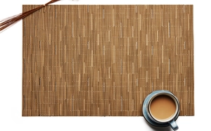 Flat lay of brown bamboo texture placemat with blue ceramic cup on white background