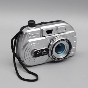 Detail view of a silver and black toy camera for dolls with black neck strap