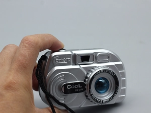 Detail of silver toy camera for 18-inch dolls with black strap and fun text graphics
