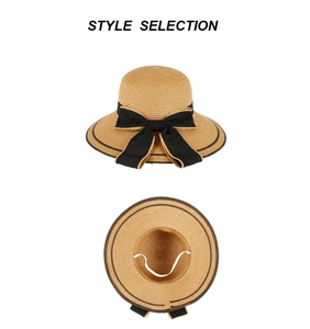 Détail d'un chapeau de paille avec nœud noir et sangle coupe-vent sur fond blanc