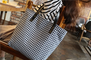 Classic blue and white checkered canvas tote bag with black leather straps and gold rivets