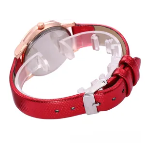 Detail view of red honeycomb textured strap and rose gold metal buckle on fashion watch