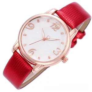 Detail of rose gold quartz watch with red snake pattern leather strap and floral dial