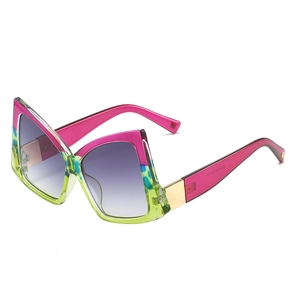 Bowtie shaped oversized sunglasses with pink and leopard print frames in purple gradient