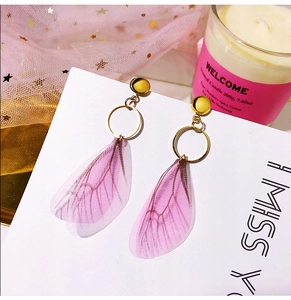 Detailed shot of purple gauze butterfly wing earrings with gold alloy studs on a white card