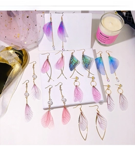 Macro detail of handmade tulle butterfly wing earrings with pearls in multiple colors