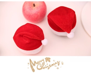 Close-up of mini red velvet Christmas hats for apples and small festive decorations