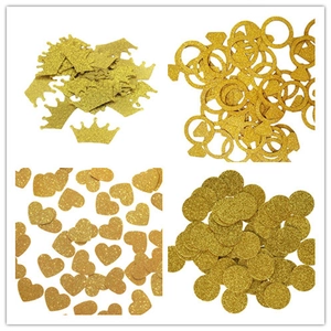 Detail of glitter graduation confetti in gold crown, ring, heart and round shapes