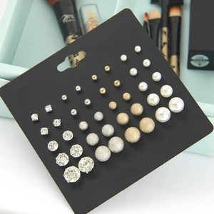 Detail of assorted stud earring set featuring pearls and crystals on a black display card