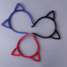 Close-up of sparkling sequined cat ear hair clips in vibrant blue, black, and red colors