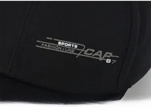 Close-up of black canvas baseball cap featuring white letter print and detailed texture
